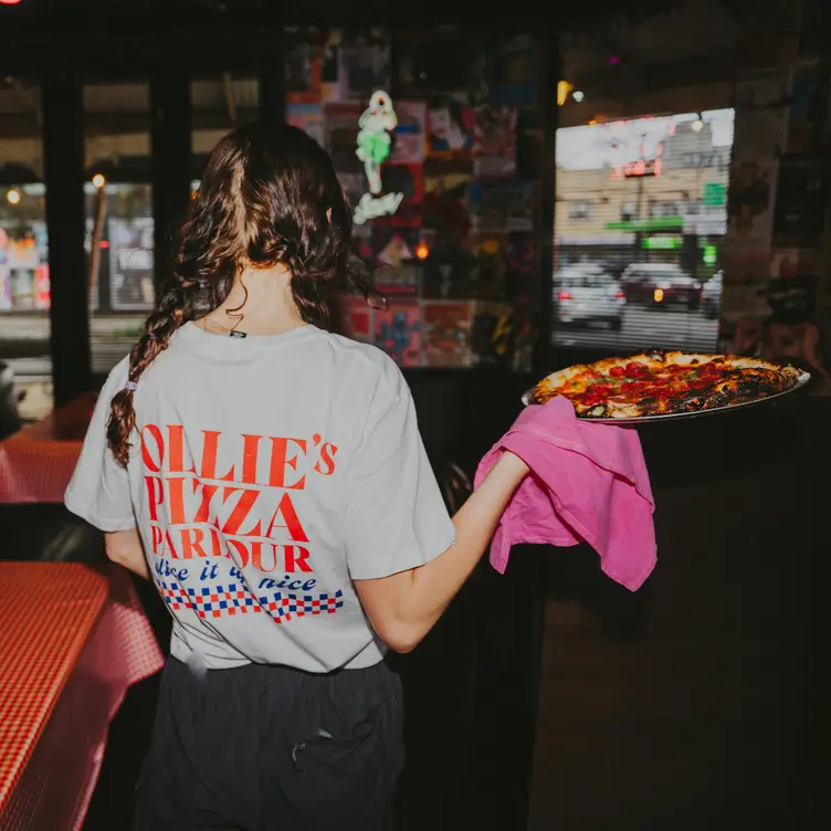 An Ollie's Pizza Parlour waitress holding pizza - Ollie's Pizza Parlour AU-VIC Brunswick