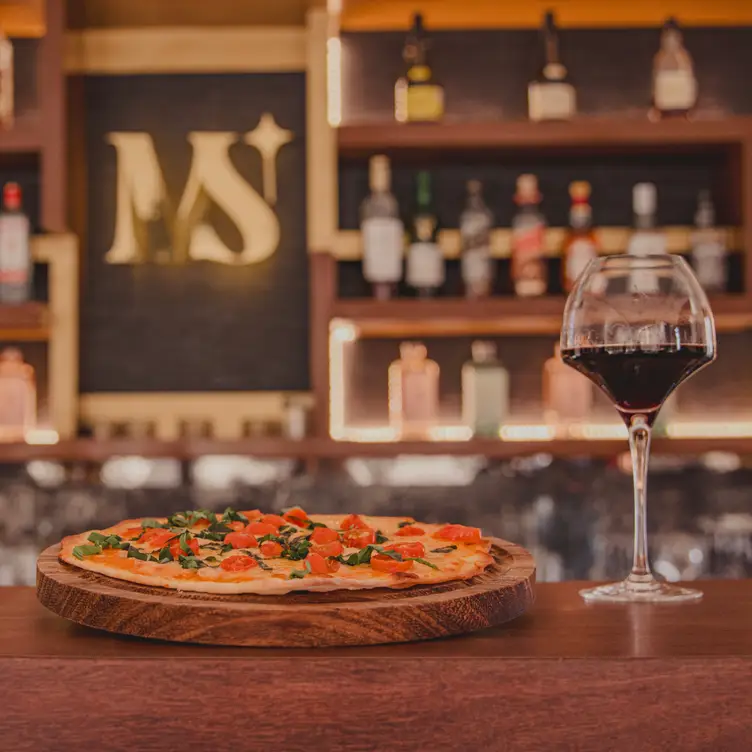 Pizza y copa de vino en barra elegante - Misión San José，BCSSan José del Cabo