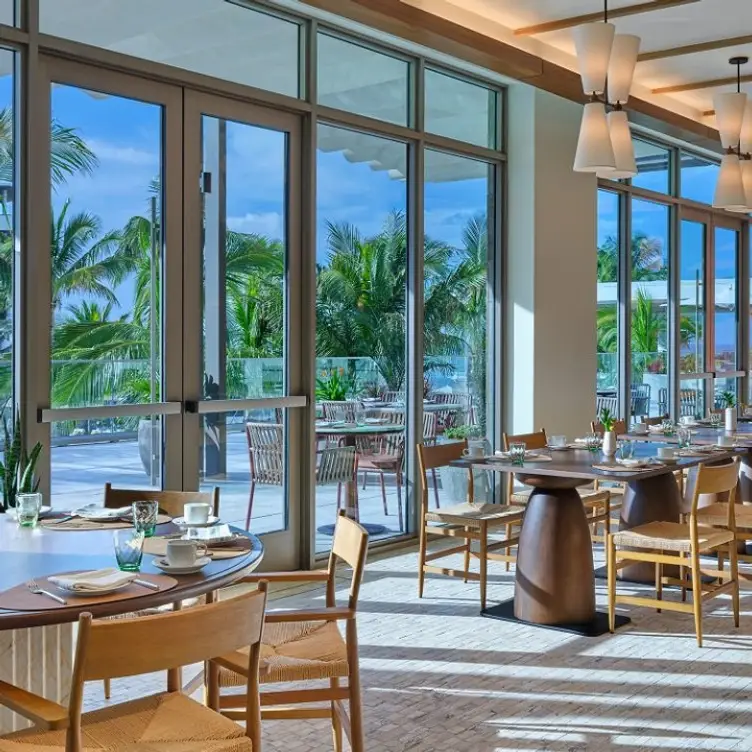 Riva at The St. Regis Longboat Key Resort dining room opening onto a palm-lined terrace.