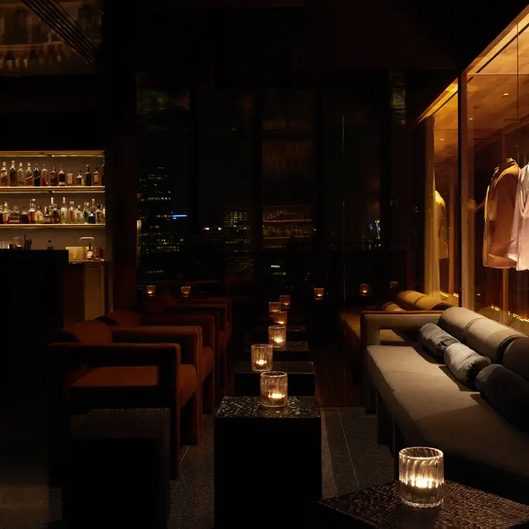 Dimly lit cocktail lounge with suits on display - The Cloakroom Bar，AU-VICSouthbank