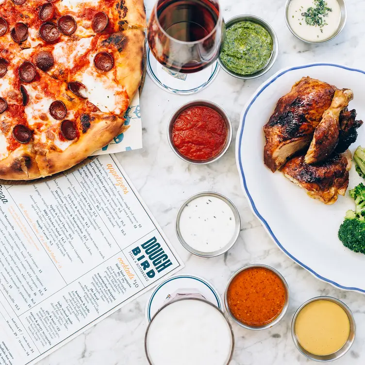 Plates of pizza, chicken, salad, and side dishes - Doughbird - North Central AZ Phoenix