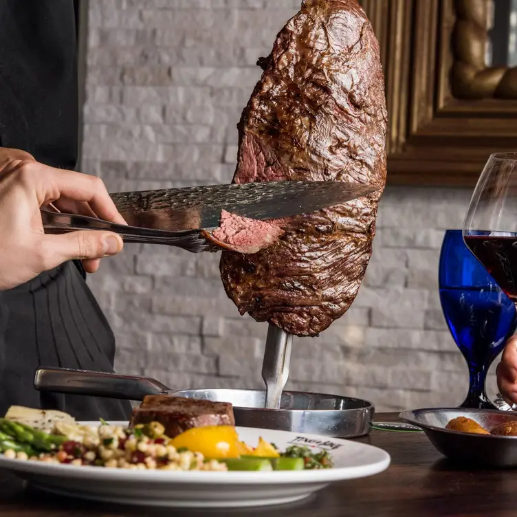 Carving flank steak at table in Texas de Brazil - Texas de Brazil - Cincinnati，OHCincinnati