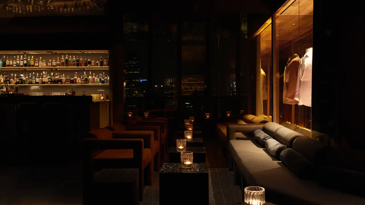 Dimly lit cocktail lounge with suits on display - The Cloakroom Bar, Southbank, AU-VIC
