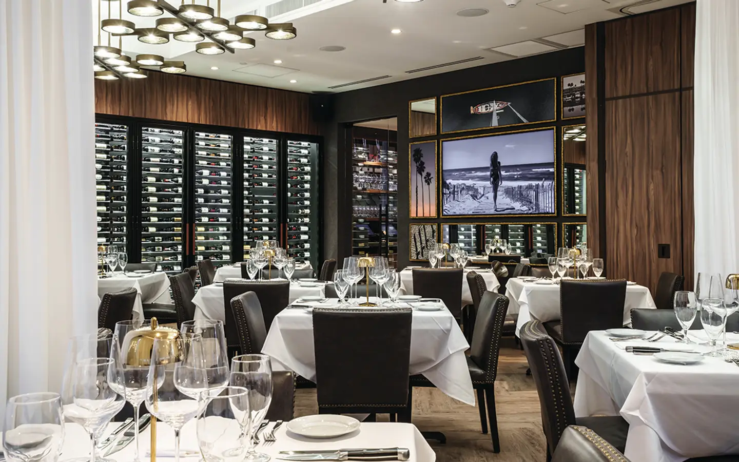 Elegant white-tablecloth dining room and wine display at Ocean 48 in Newport Beach