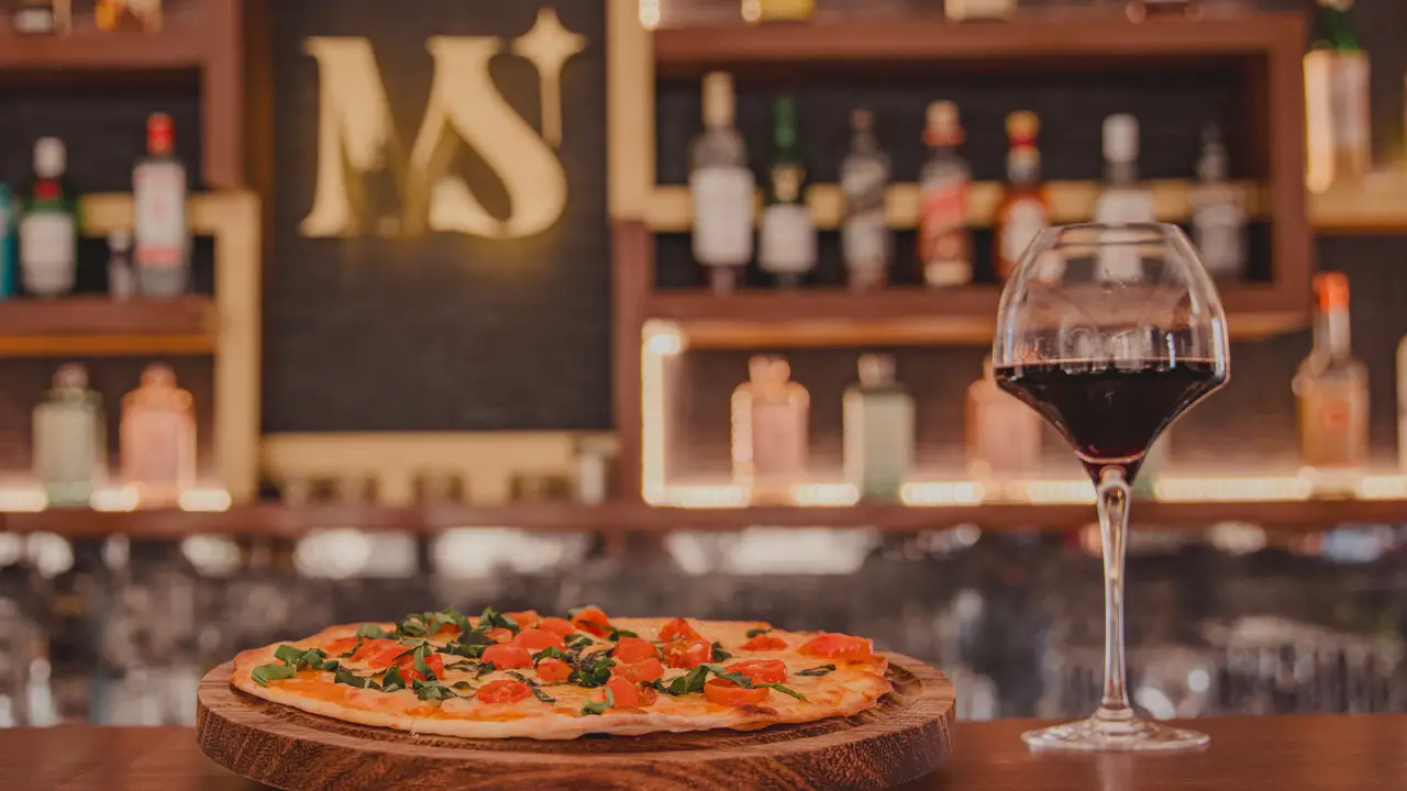 Pizza y copa de vino en barra elegante - Misión San José, San José del Cabo, BCS